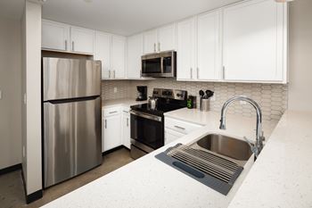A kitchen with white cabinets and stainless steel appliances